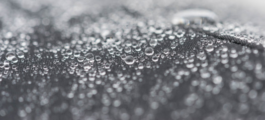 Closeup detailed view of raindrops on a fabric, a background.