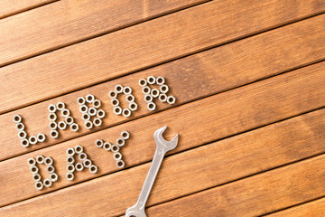 Labor day - The inscription  and wrench . On wooden background