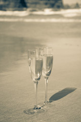 Two glasses of champagne or cava sparkling wine served on the white sandy tropical beach, luxury resort with sea view, romantic vacation