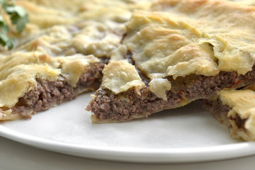 Ossetian pie with stuffing. Homemade pie on a white background