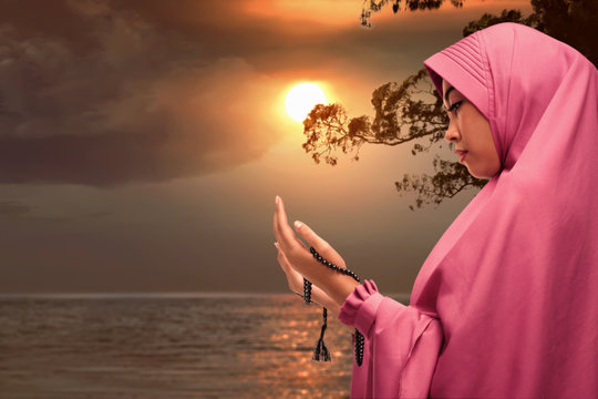 Beautiful asian muslim woman praying with prayer beads