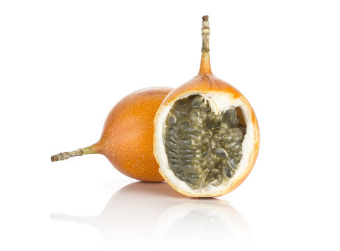 Two giant grenadilla one split with juicy flesh and seeds isolated on white background sweet yellow passion fruit.