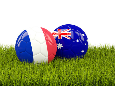 France vs Australia. Soccer concept. Footballs with flags on green grass