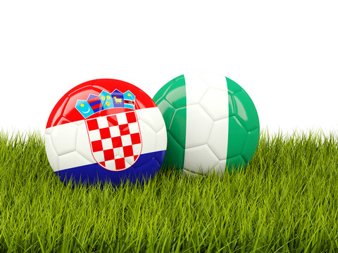 Croatia vs Nigeria. Soccer concept. Footballs with flags on green grass