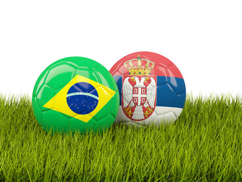 Brazil vs Serbia. Soccer concept. Footballs with flags on green grass