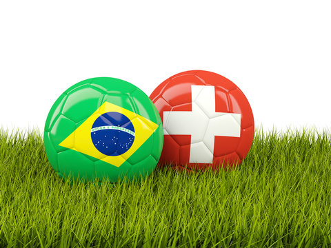 Brazil vs Switzerland. Soccer concept. Footballs with flags on green grass