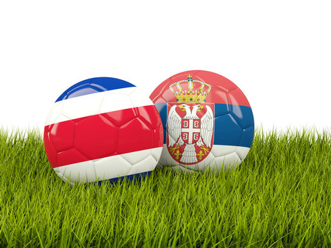 Costa Rica vs Serbia. Soccer concept. Footballs with flags on green grass