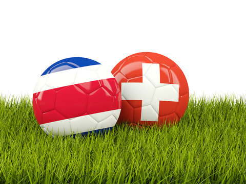 Costa Rica vs Switzerland. Soccer concept. Footballs with flags on green grass