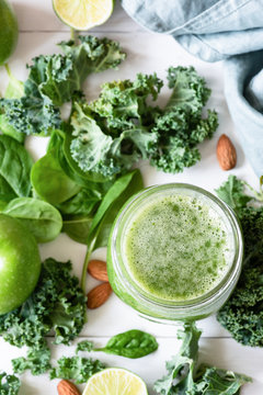 Smoothie detox with green fruits, vegetables, spinach and kale on white. Green smoothie and ingredients. Top view, selective focus
