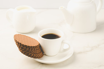 breakfast in white ceramic ware and cookies/breakfast in white ceramic ware and cookies on white background. Selective focus