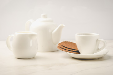 Obraz na płótnie Canvas breakfast in white ceramic ware and cookies/breakfast in white ceramic ware and cookies on white marble background