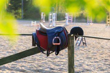 Horseback saddle on the wooden fence in a sunny day
