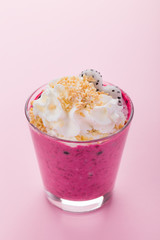 Smoothie in glass with berries on pink