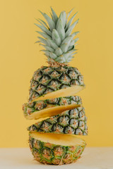 Colorful sliced pineapple on yellow