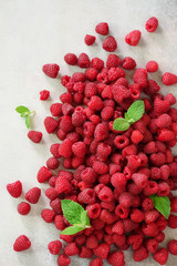 Fresh organic raspberries with mint leaves. Fruit background with copy space. Summer and berries harvest concept. Vegan, vegetarian, raw food.