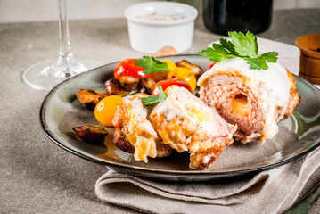 Homemade meat cutlet cordon bleu, grey stone background copy space