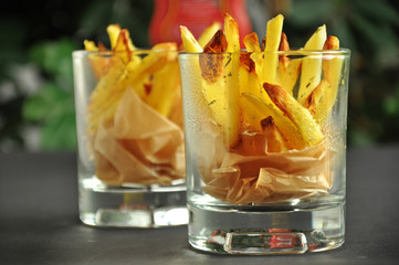 French fries in a glass on black background