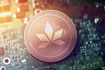 shiny copper PARAGON cryptocurrency coin on blurry motherboard background