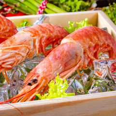 cooked argentine red prawns with salad on the ice