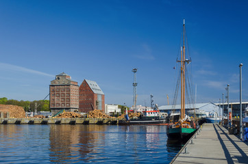 Fototapeta na wymiar SEA PORT - Old grain warehouses and a sailboat at the wharf 
