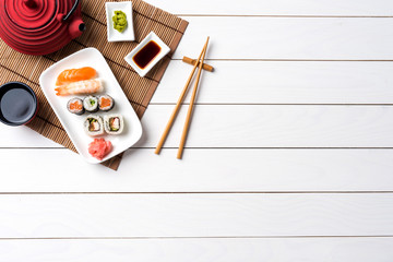 Set of sushi with red teapot and chopsticks. Top view