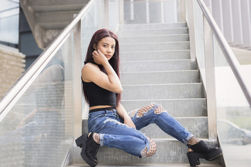 Girl sitting on a stairs with fashion pose