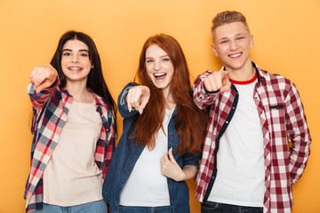 Group of happy school friends pointing fingers at camera