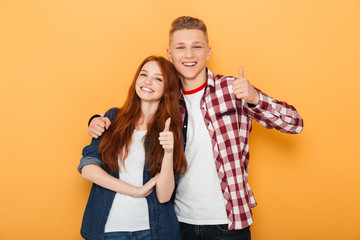 Portrait of a happy teenage couple showing thumbs up