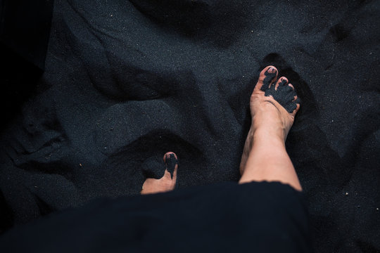 Woman's Feet On Black Sand From Above