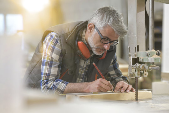 Woodworker in workshop designing piece of wood