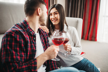 Love couple watches movie and drinks red wine