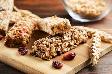 Bunch of mixed gluten free granola energy bars with dried fruit & various nuts, wooden background. Healthy vegan super food, different fitness diet snacks for sporty lifestyle. Top view, copy space.