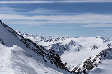 Verschneite Winterlandschaft über den Alpen unter blauem Himmel