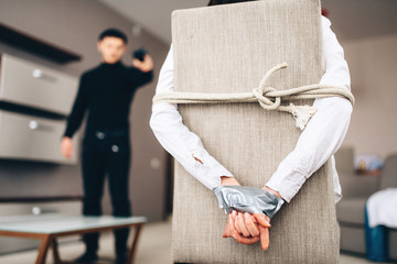 Robber scares female victim tied to the chair