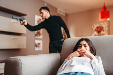 Obraz premium Woman hiding against killer with gun