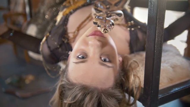 Portrait of young female dancer lying with a python