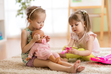 children playing doctor with doll in playschool