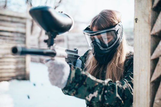 Female paintball player with marker gun in hands