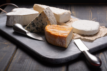 French cheeses plate in assortment, blue cheese, brie, munster, soft goat cheese