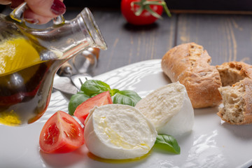 Traditional italian food - white ball mozzarella buffalo Italian soft cheese with cheese knife, tomato, basil, olive oil