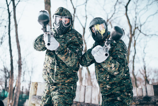 Paintball players in splattered masks after battle