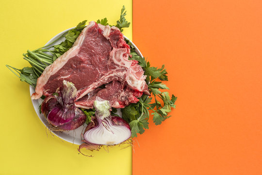 Raw beef steak. Rosemary, chilli peppers.