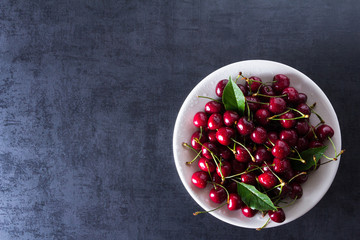 Fresh red ripe cherries on white plate