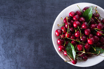 Fresh red ripe cherries on white plate