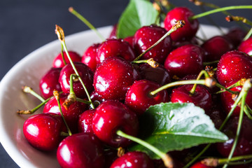 Fresh red ripe cherries on white plate