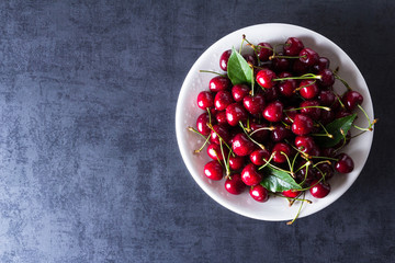 Fresh red ripe cherries on white plate