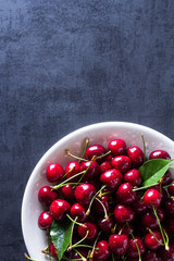 Fresh red ripe cherries on white plate