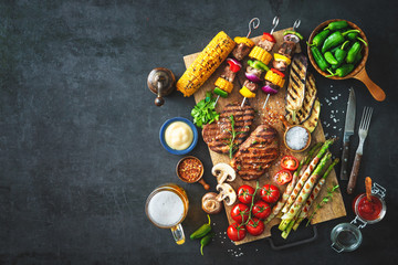 Grilled meat and vegetables on rustic stone plate - obrazy, fototapety, plakaty