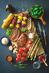 Grilled meat and vegetables on rustic stone plate