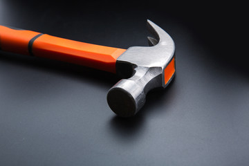 Orange hammer on dark matt background, closeup